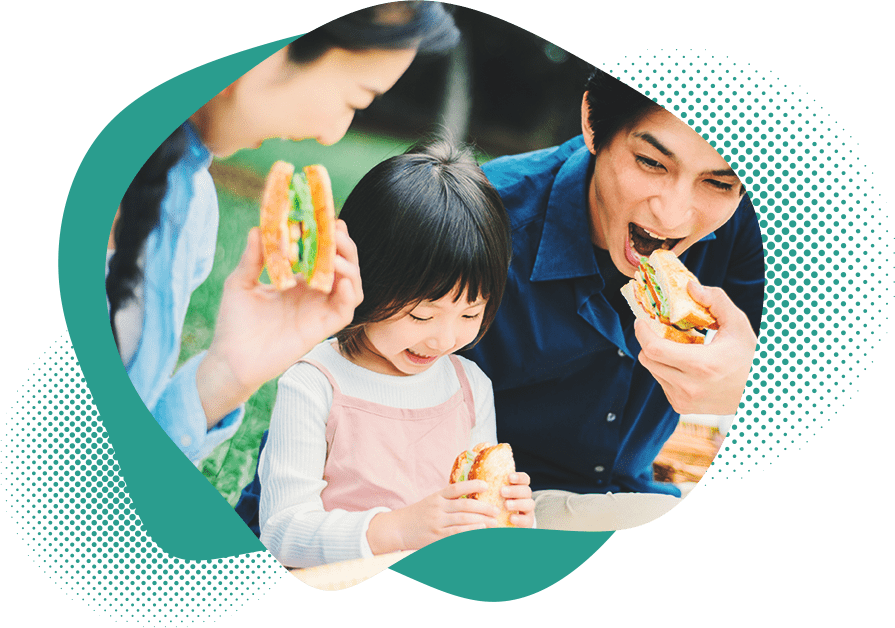 サンドイッチを食べる家族の写真